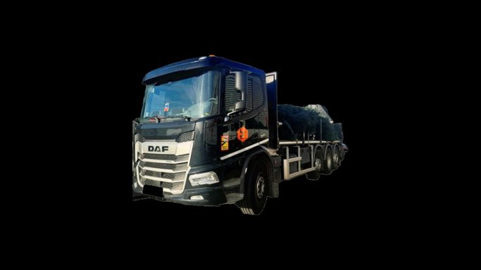 Camion de transport noir avec une citerne, sur fond noir.