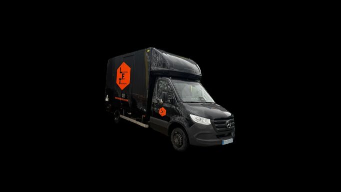 Camion noir avec un logo orange sur le côté.